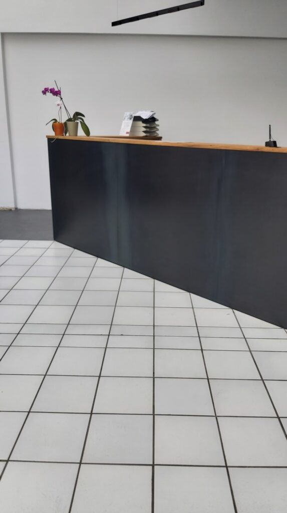 Empfangstresen im minimalistischen Stil. In Stahl und Massivholz.